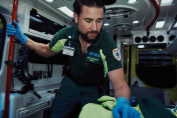 Manlig ambulanssjuksköterska som arbetar i en ambulans.