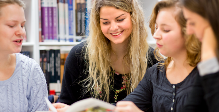 Fyra studenter på bibliotek