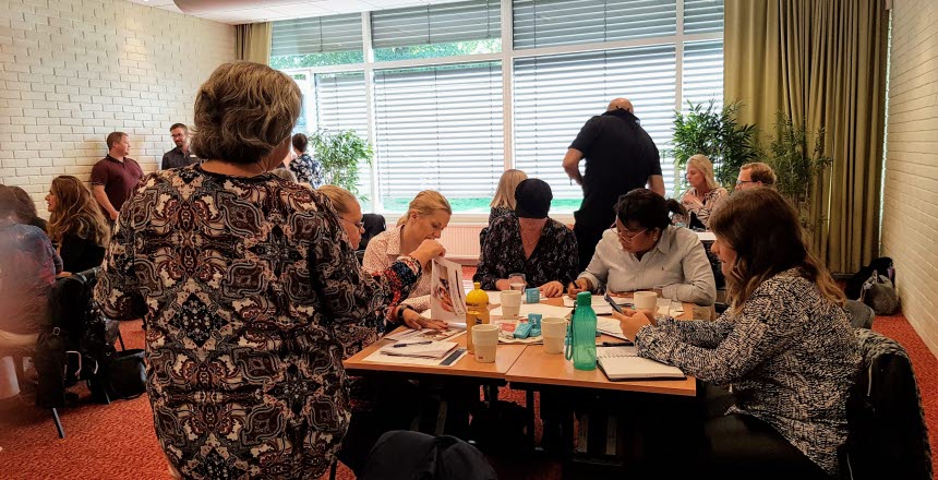 Människor som sitter och arbetar i ett konferensrum