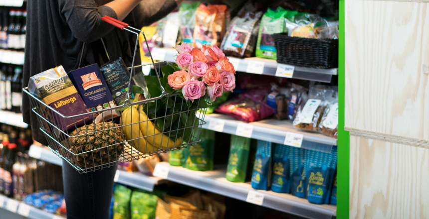Kvinna i butik med fair trade-varor i varukorg