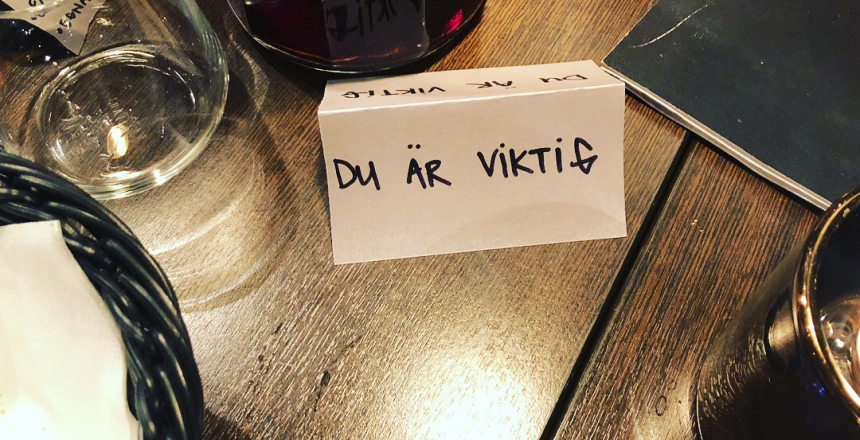 Närbild på ett dukat bord där man ser ett glas, någon lykta och en brödkorg. Det finns även en lapp som det står Du är viktigt på.